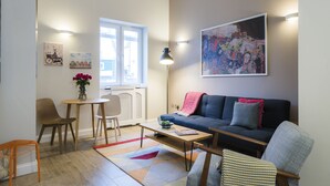 A modern living room with a sofa, chairs, a coffee table, and artwork on the walls. - Westbourne Gardens by Lime Street (London)