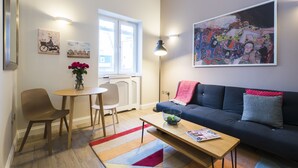 A modern living room with a sofa, a coffee table, a dining table with chairs, and artwork on the walls. - Westbourne Gardens by Lime Street (London)