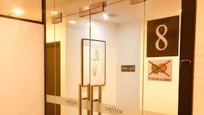 A glass-walled elevator with a sign reading "THEVIEW" and a no-dragons allowed sign. - The View Hotel (Segamat)