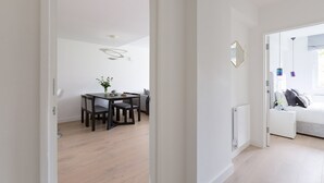 A modern interior with a dining area, a sofa, and a bed. - Craven Hill by Lime Street (London)