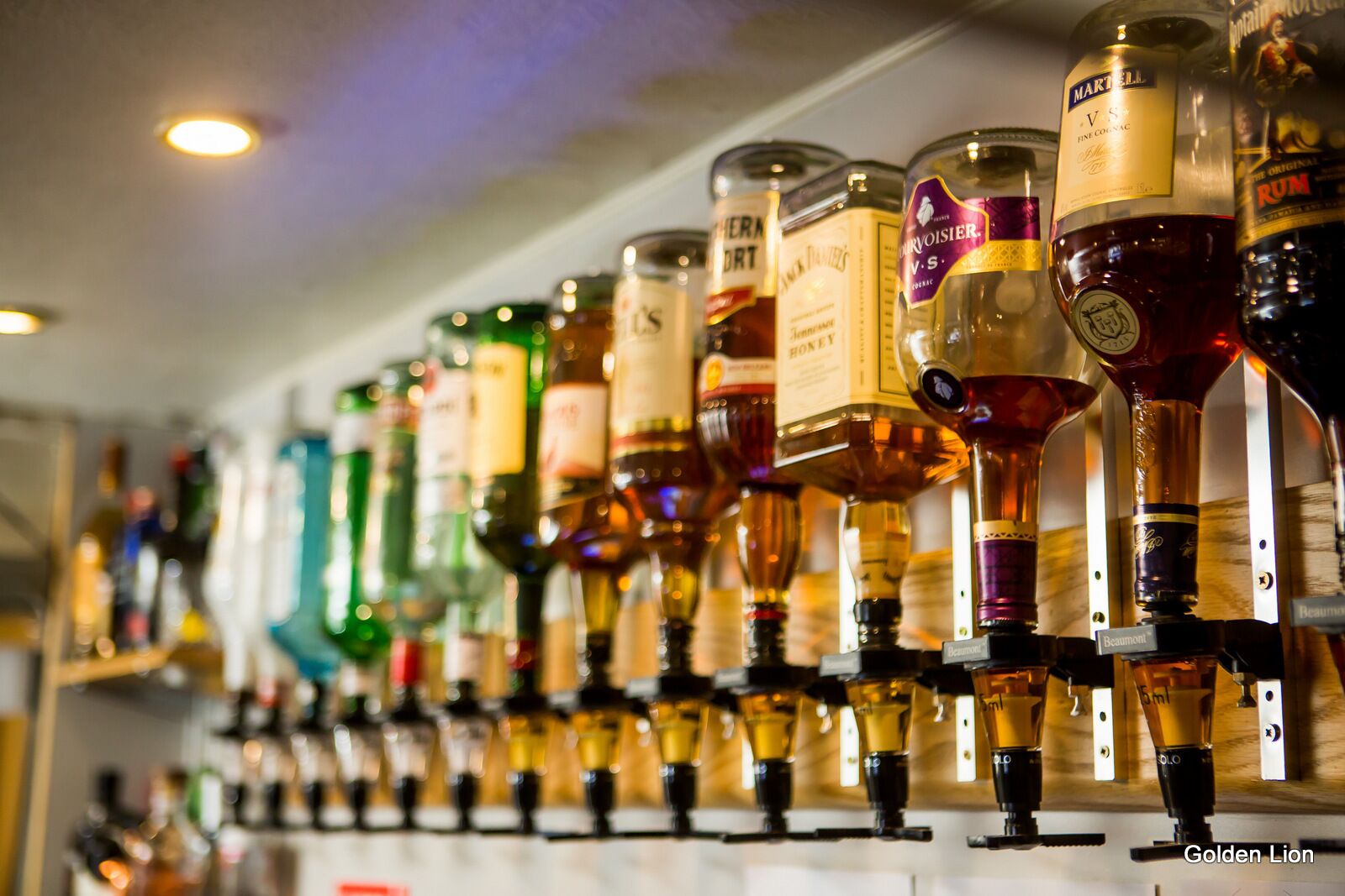 A bar with a variety of liquor bottles and taps.