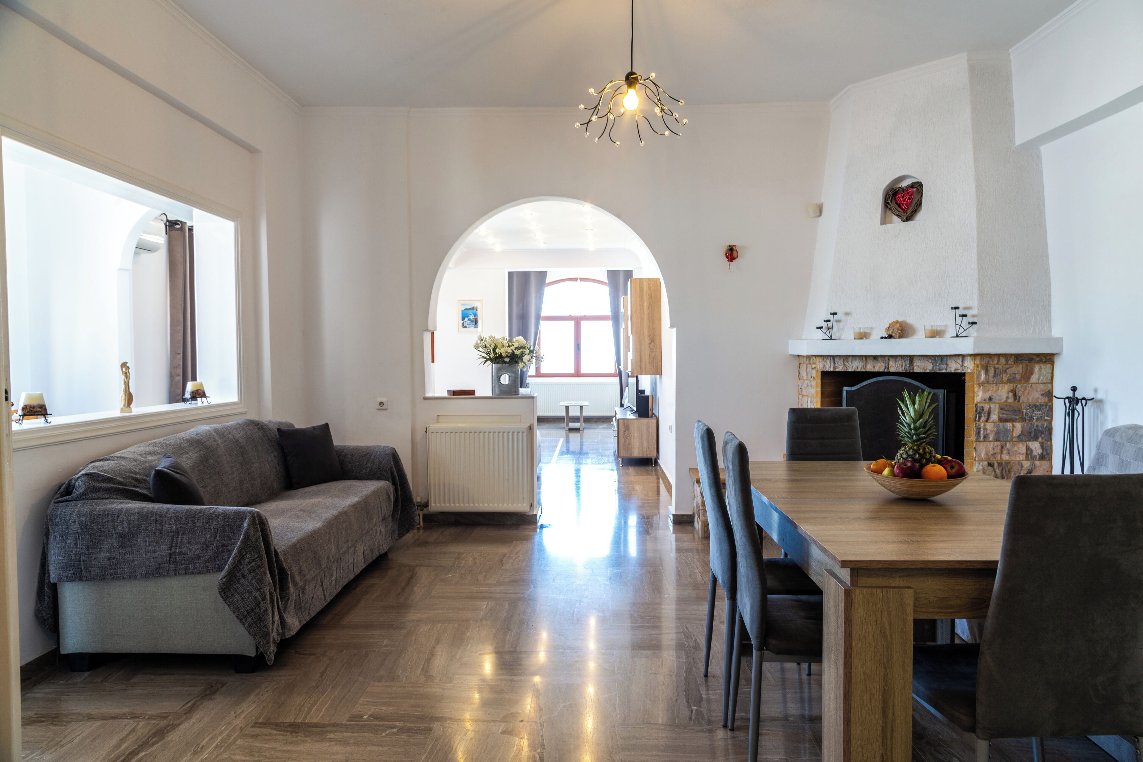 Una sala moderna con sofá, mesa de comedor y chimenea.