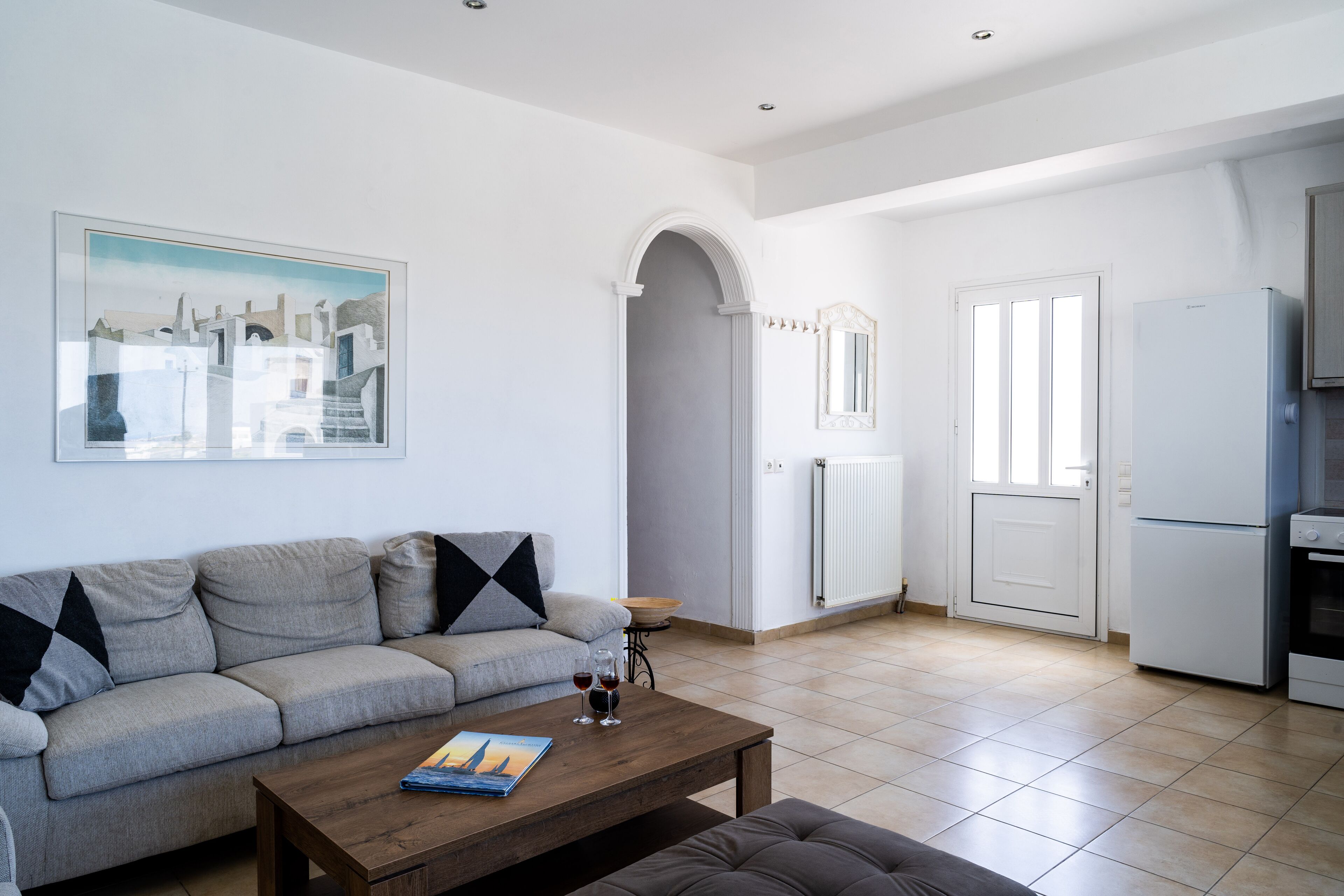 Un salon avec un canapé, une table basse et un tableau accroché au mur.