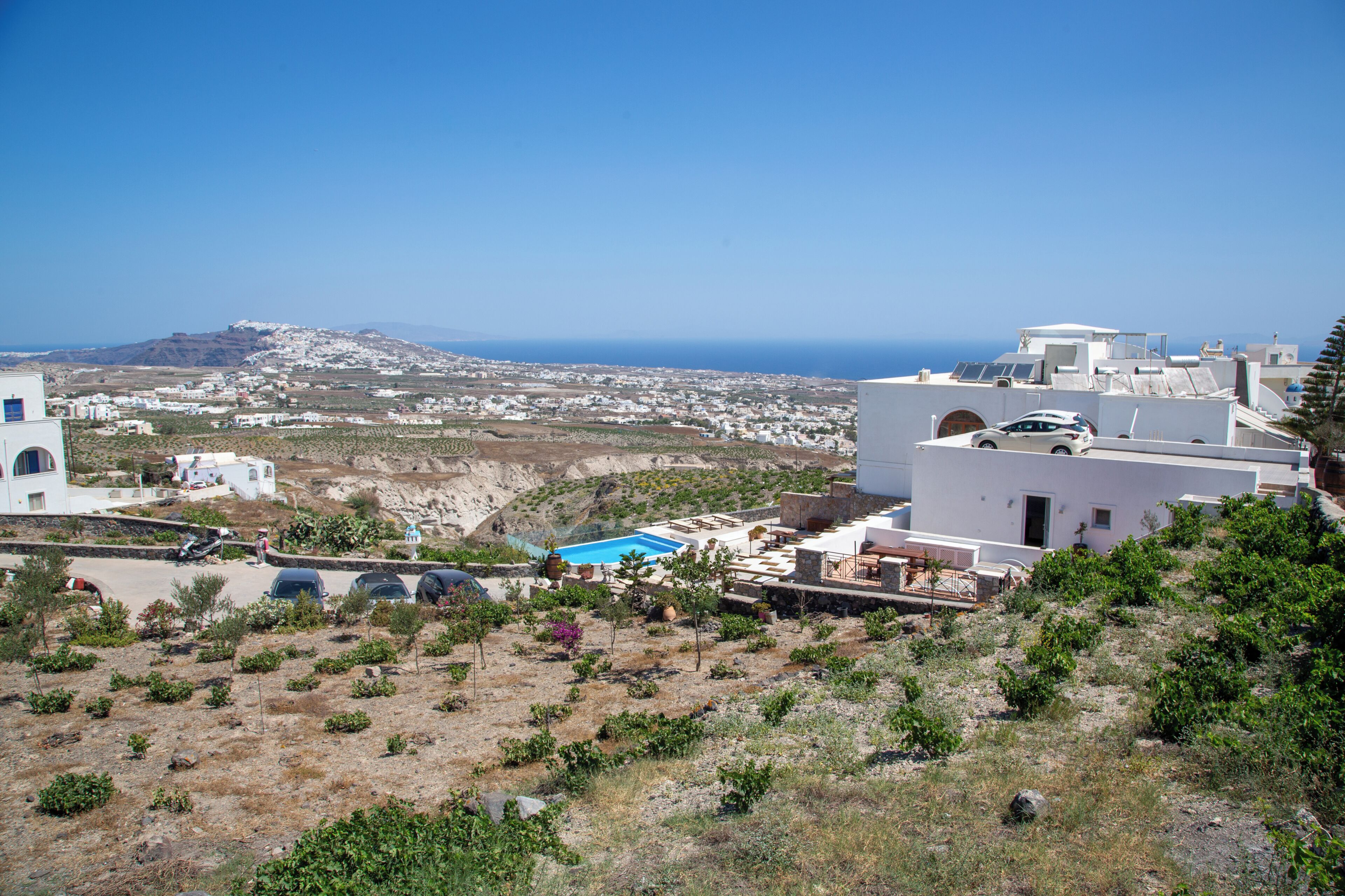 Un pueblo costero con edificios blancos, una piscina y vista al mar.