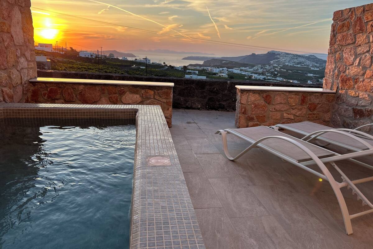 Zona de piscina en la azotea con vistas a la puesta de sol y edificios a lo lejos.