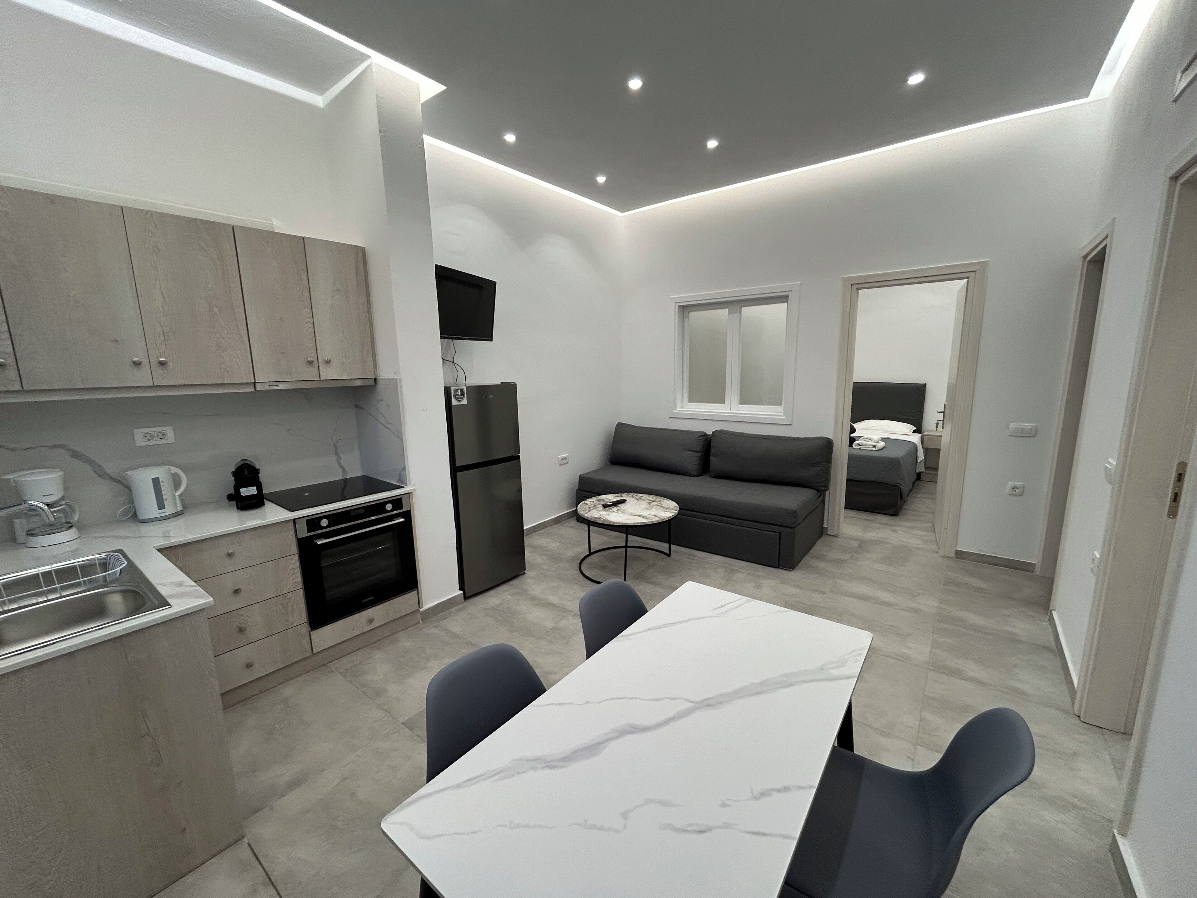 Eine kompakte, moderne Wohnung mit Küche, Essbereich und einer kleinen Wohnfläche.