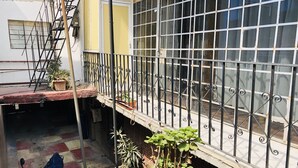 A courtyard with a scooter, potted plants, and a metal railing. - Mexica Apartment 20-30 min from the Airport (San Miguel Xalostoc)