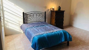 A bedroom with a bed, a dresser, and a wall-mounted lamp. - Mexica Apartment 20-30 min from the Airport (San Miguel Xalostoc)