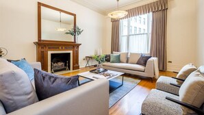 A living room with a fireplace, sofas, a coffee table, and a large mirror. - Cleveland Square Mansions (London)