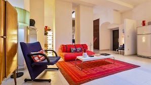 A modern living room with a blue chair, red sofa, and a coffee table. - Rome as you feel - Selci Apartment (Rome)
