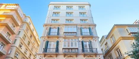 Un immeuble à plusieurs étages doté de balcons, de grandes fenêtres et d’un style architectural classique.