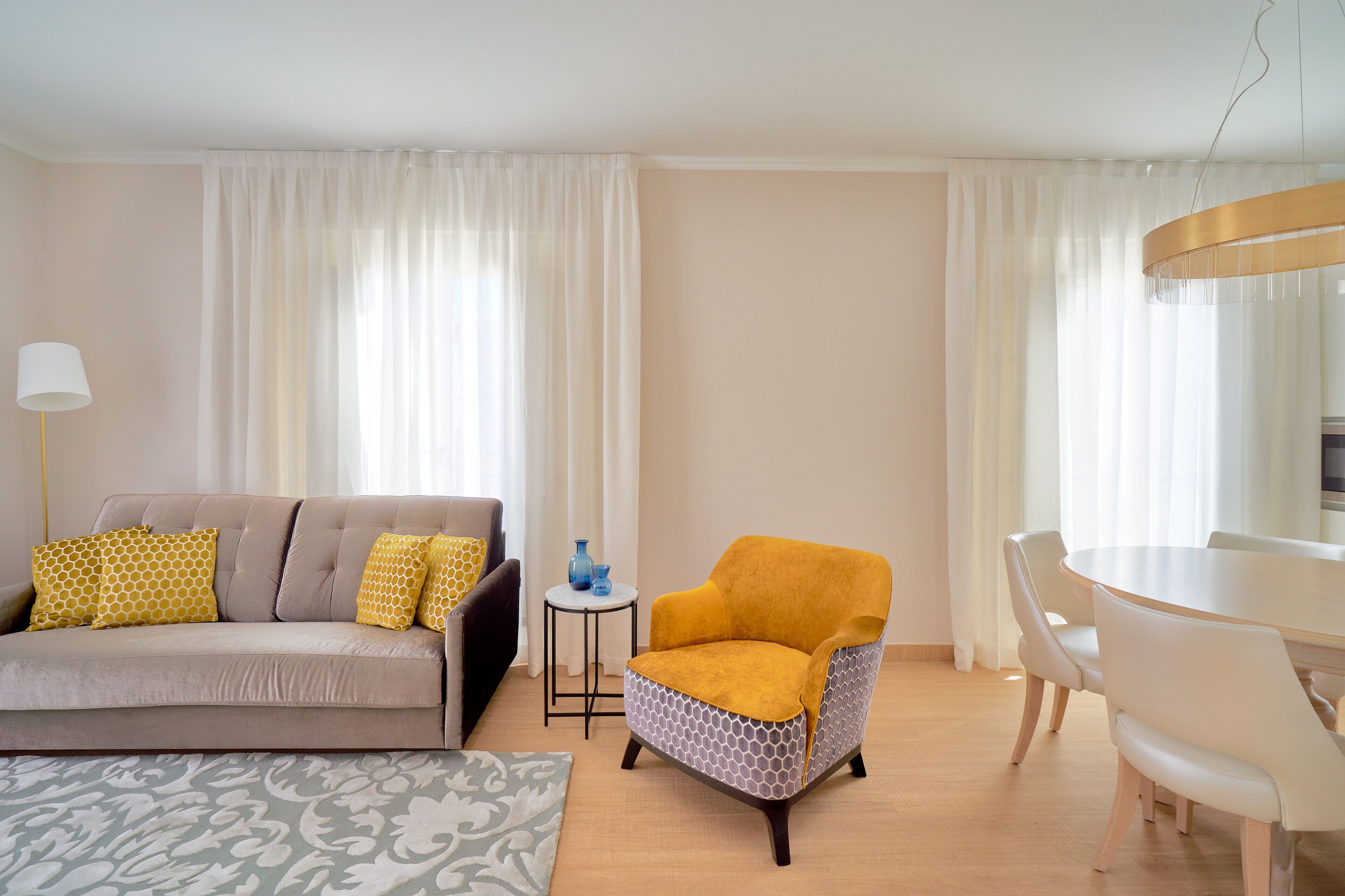 Una sala de estar con sofá, sillón y mesa de comedor.