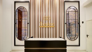 Un interno moderno con due finestre ad arco, un pannello verticale centrale con un logo e un faretto a soffitto.