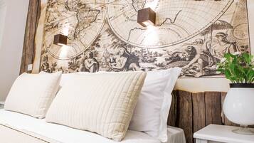 Un dormitorio con un mural grande de un mapa en la pared, una cama con ropa de cama blanca y una mesita de noche con una lámpara.