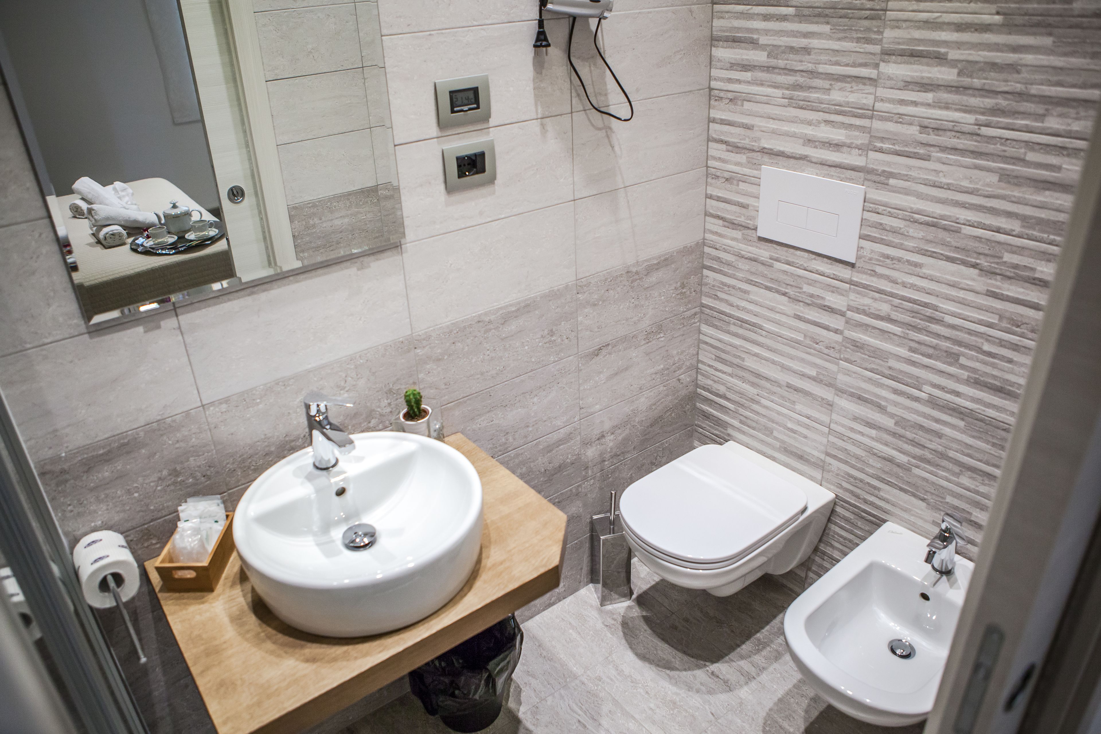 A modern bathroom with a large sink, a bidet, and a mirror.