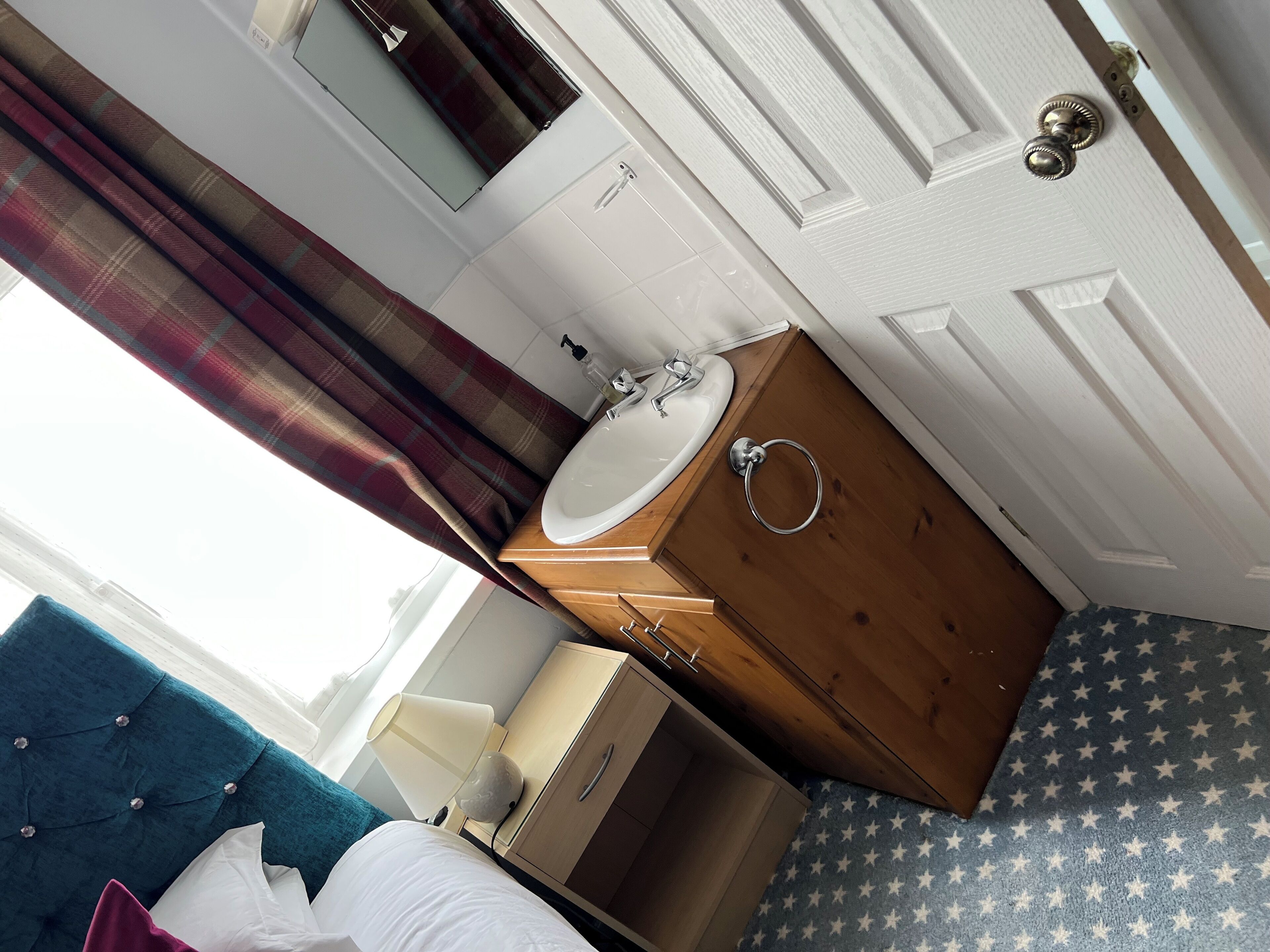 Un baño con un mueble de madera, un lavabo blanco y un espejo.