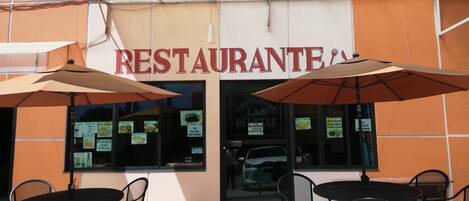 A restaurant with outdoor seating and umbrellas.