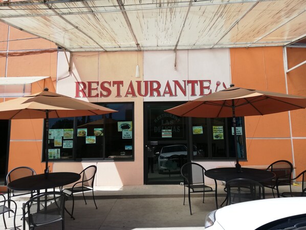 A restaurant with outdoor seating and umbrellas.