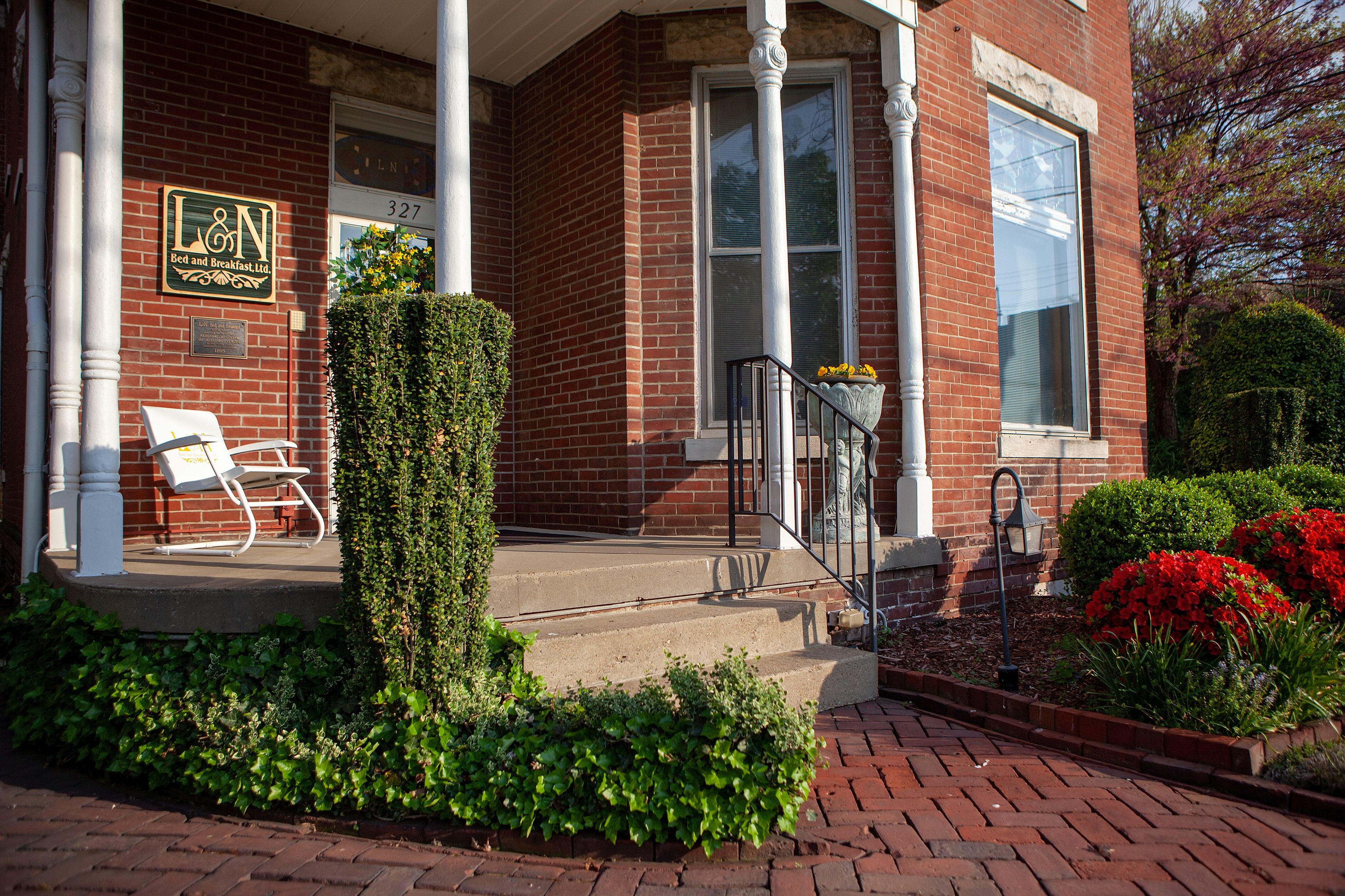 A brick building with a sign reading "L&N Bed and Breakfast Ltd." and a bench outside.