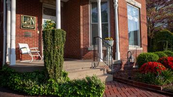 A brick building with a sign reading "L&N Bed and Breakfast Ltd." and a bench outside.