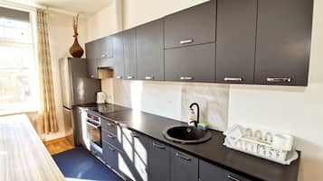 Departamento Confort, vista a la ciudad | Cocina privada | Refrigerador con congelador, horno y parrilla de estufa