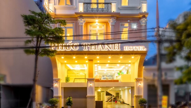 A multi-story hotel with illuminated signage and balconies. - Phuc Thanh Hotel (Da Nang)