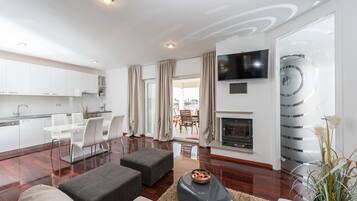 Apartamento luxo, vista para o mar | Sala de estar | TV de tela plana