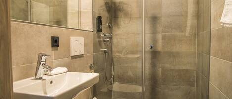 A modern bathroom with a sink, toilet, and glass-enclosed shower.