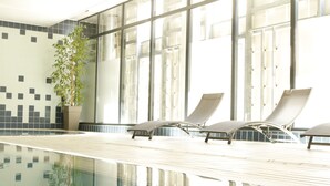 A swimming pool area with lounge chairs and a potted plant. - Hotel College des Doctrinaires, BW Premier Collection (Lectoure)