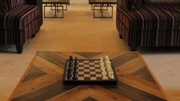 A spacious living room with a fireplace, two sofas, and a chessboard on a coffee table.