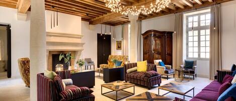 A spacious living room with a fireplace, modern furniture, and a large window.