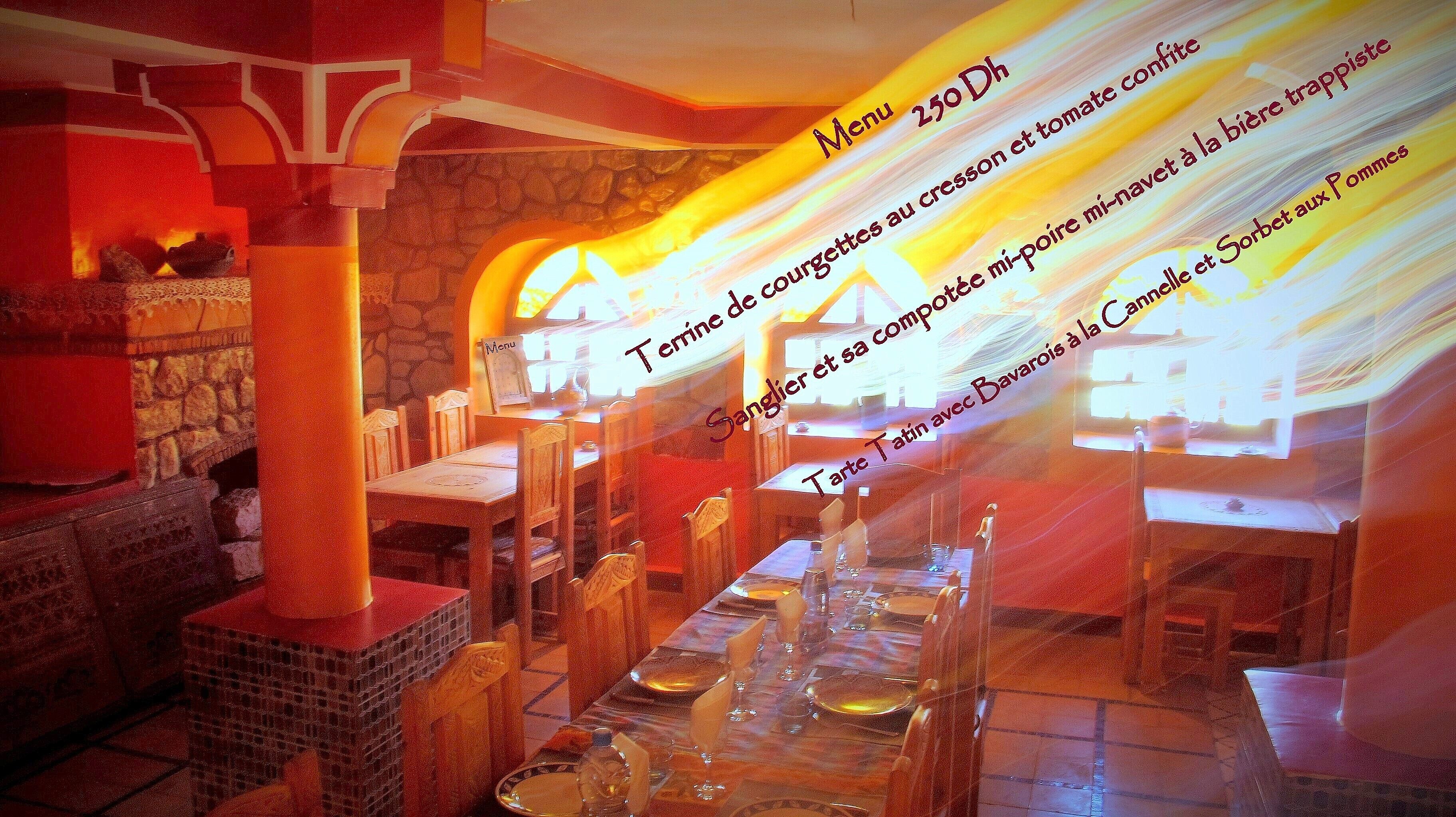 A restaurant interior with stone walls, wooden furniture, and a menu board.