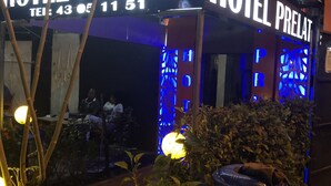 Un edificio con la scritta "HOTEL PRELAT" e un numero di telefono.