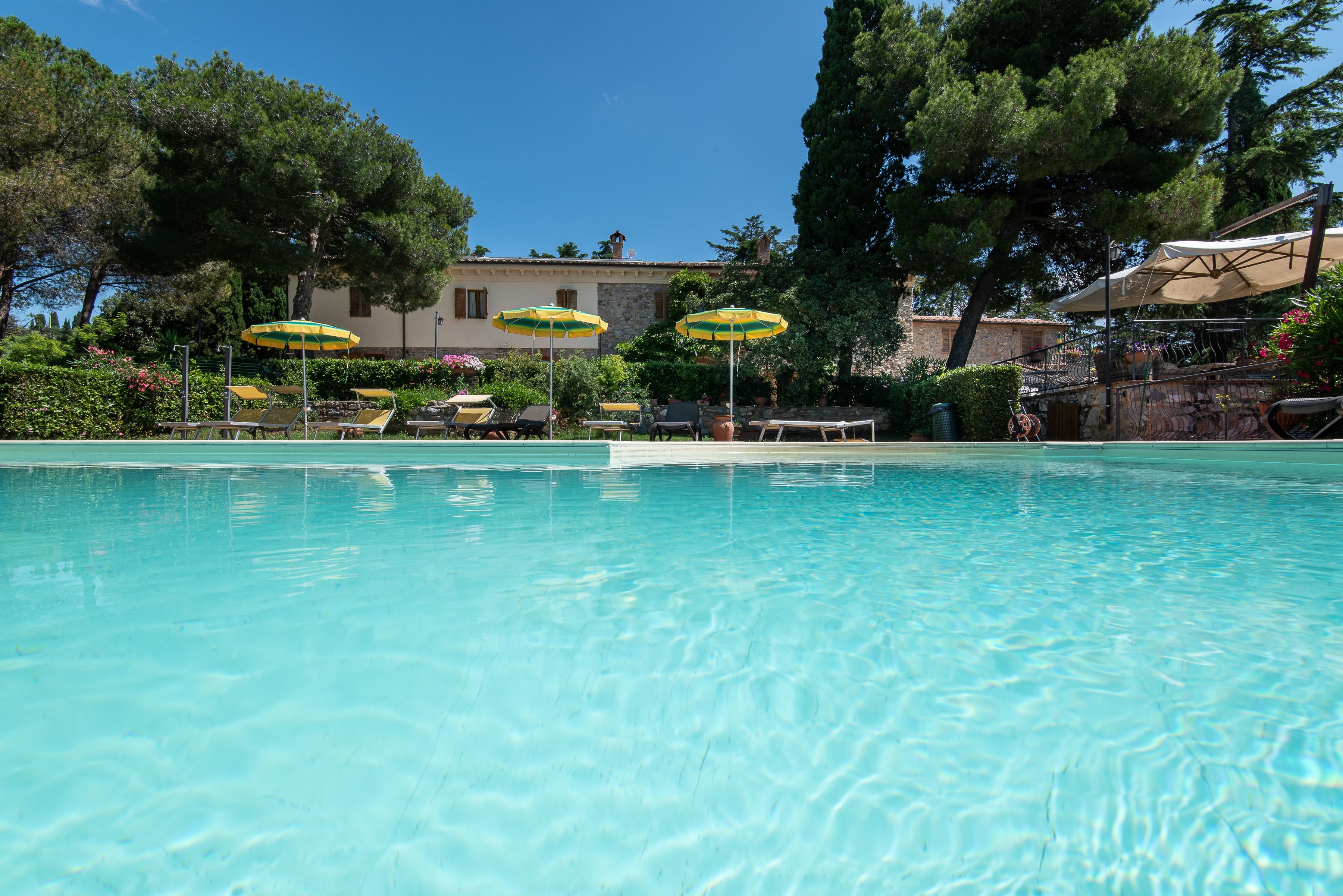 Una piscina al aire libre de temporada, sombrillas