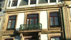 A multi-story building with a classic architectural style, featuring arched windows and decorative balconies. - Citybreak Apartments Bolhão (Porto)