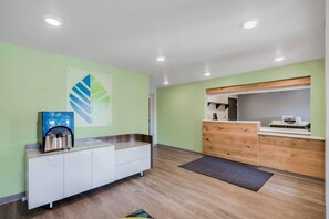 A reception area with a modern design, featuring a reception desk, a coffee machine, and a wall-mounted artwork.