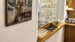 Una cocina con pared de piedra, mostrador de madera y un letrero que dice "Bienvenue au Chalet Jura".