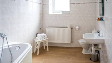 A bathroom with a bathtub, toilet, and sink.