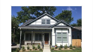 A two-story house with a front porch, a garage, and a fenced backyard. - NEW The Icon House, East Nashville (Nashville)