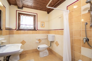 Une salle de bain équipée de toilettes, d’un bidet et d’un lavabo.