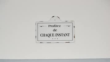 Un mur avec deux panneaux : l’un porte l’inscription « Profitez de CHAQUE INSTANT » et l’autre, « BAGAGERIE ».