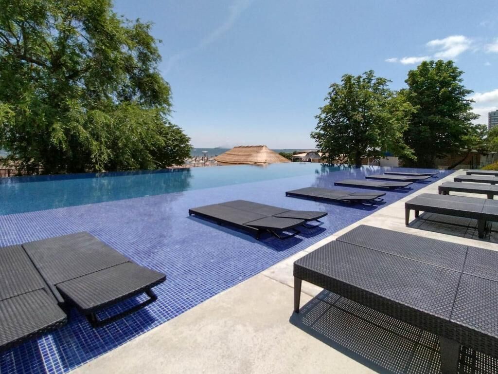 A swimming pool with lounge chairs and a view of the landscape.