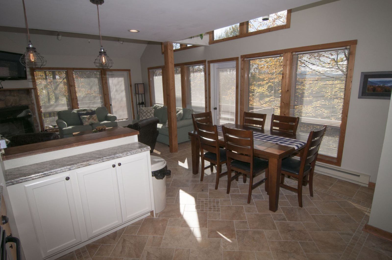 Una cocina amplia con comedor, ventanas grandes y chimenea.