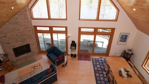 A spacious loft with a high ceiling, large windows, a fireplace, and a cozy seating area. - Woodland Pond (Davis)