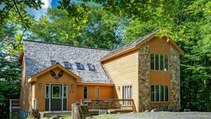 A two-story log cabin with a stone extension, a front porch, and a number 15 sign. - White Diamond (Davis)