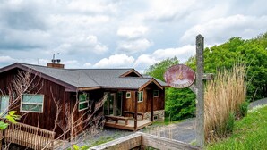 A rustic cabin with a wooden exterior, a porch, and a sign indicating 'Suquet House 14 Mountainside'. - Sunset House (Davis)