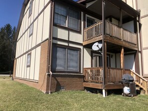 A two-story building with a balcony on the second floor, a satellite dish, and a grill on the deck. - Talheim Village A9 (Davis)