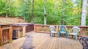 A wooden deck with a covered seating area, surrounded by a forest. - Paradise Found (Davis)