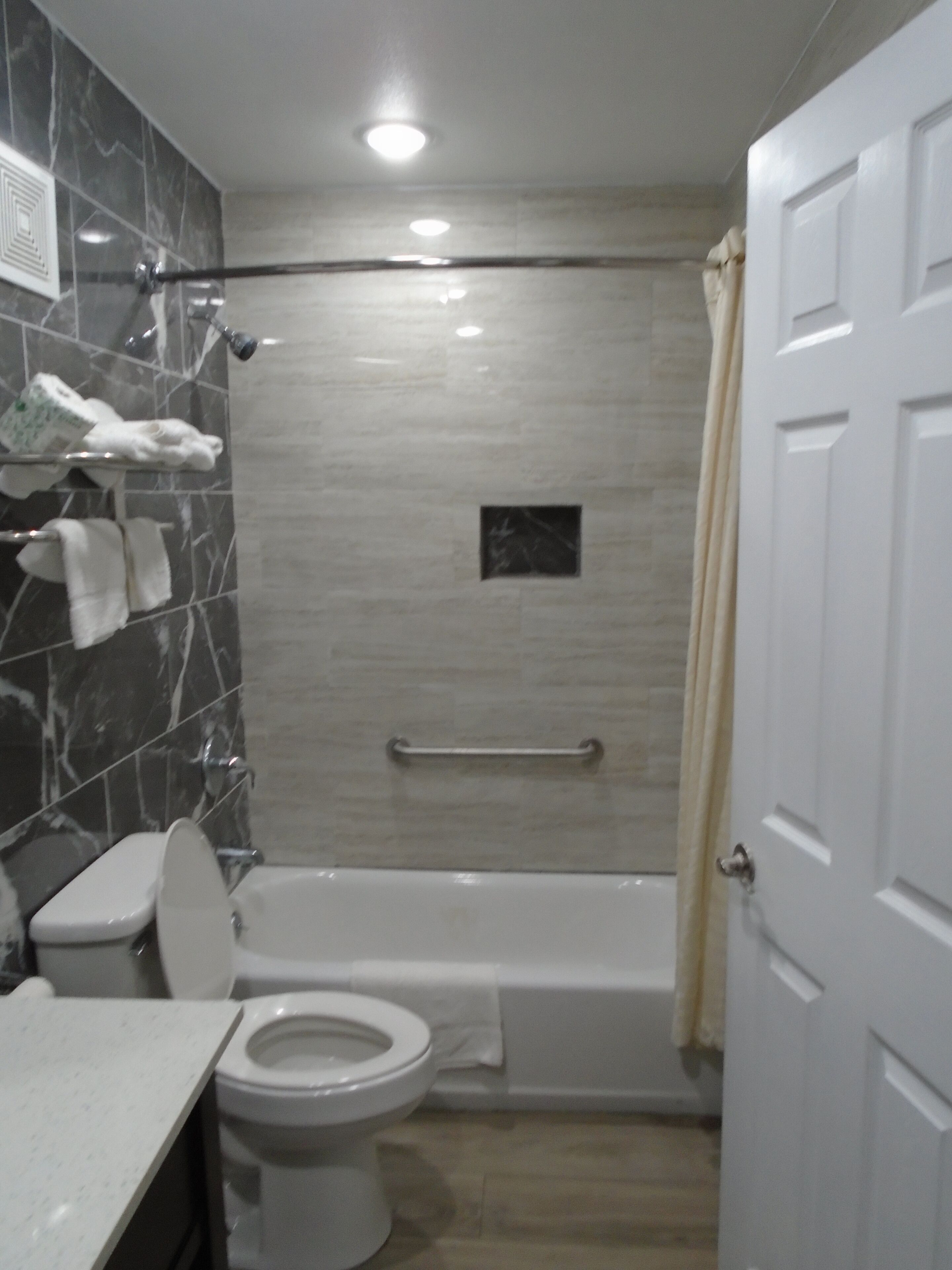 A bathroom with a toilet, sink, and bathtub.