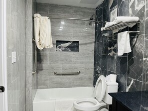 Un baño moderno con bañera, inodoro y ducha.